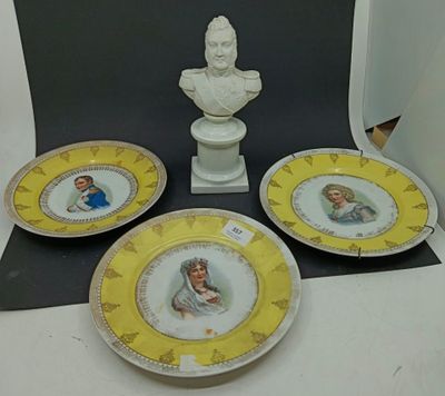 trois assiettes et un buste d'homme posé sur une table