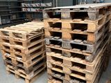 many pallets of wood stacked up in a warehouse