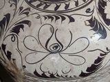 a large vase with designs on it sitting on a table