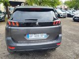 the back end of a grey car parked in a parking lot