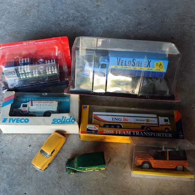 beaucoup de petites voitures et de camions dans des cartons posés par terre