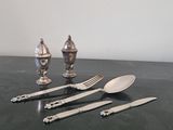 beaucoup de couverts sur une table où se trouvent déjà des couverts