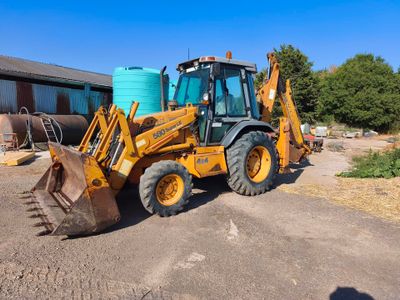 a tractor that is parked in a lot next to a building