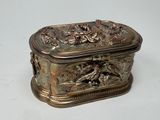 a silver box with a design on it on a white surface