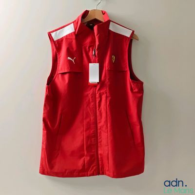 a red vest hanging on a wall next to a hanger