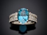 a close up of a ring with a blue topaz stone surrounded by white diamonds