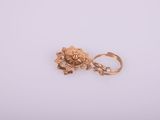 gros plan d'une paire de boucles d'oreilles en or sur une surface blanche