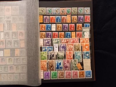 un livre ouvert, orné de timbres, posé sur une surface noire