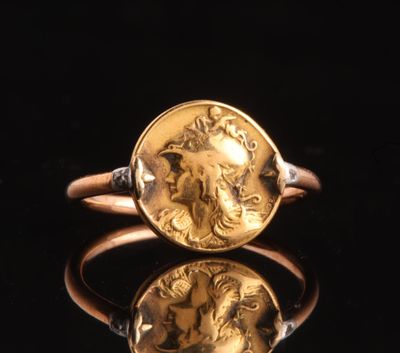 a gold ring with a roman coin on top of it