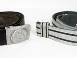 pair of leather belts with metal buckles on a white surface