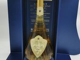 une bouteille de champagne dans un coffret cadeau bleu, posée sur une surface blanche