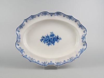 blue and white platter with blue flowers on it on a stand