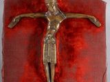a metal crucifid on a red cloth