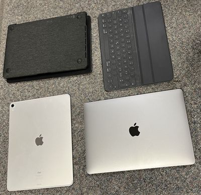 three laptops and a keyboard on the floor