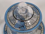 a blue and white plate with a glass lid on it