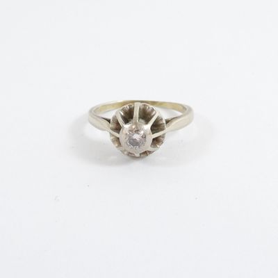 a close up of a diamond ring on a white surface