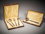 une paire de couverts dans un coffret en bois posé sur une surface grise