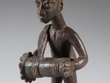 une figurine en bronze représentant un homme tenant une pipe