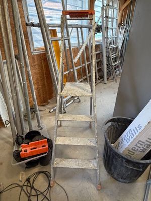 a room with a ladder and a bucket of tools in it
