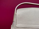 a close up of a white purse with a red background