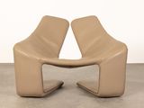 pair of tan leather lounge chairs in the shape of a chair