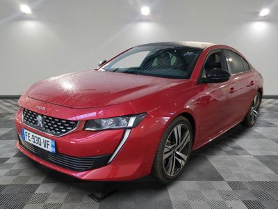 la voiture rouge est garée dans le garage sur un sol en damier