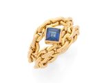 une bague en or sertie d'une pierre bleue et entourée d'une chaîne