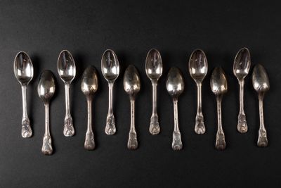six silver spoons lined up in a row on a black surface