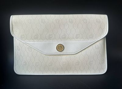un sac à main blanc orné d'un bouton doré sur le devant