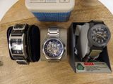 two watches and a watch box on a wooden table