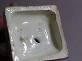someone is holding a small square shaped object with a hole in it