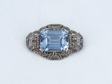 an art deco ring with a blue topaz stone surrounded by diamonds