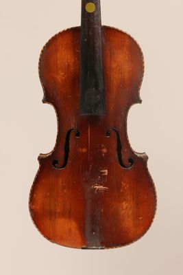 un vieux violon posé sur une surface blanche