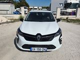 une voiture blanche garée sur un chemin de terre devant un bâtiment