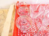 des bouteilles et des verres posés sur un plateau, avec un plateau rouge en dessous