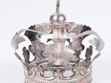 silver crown with a cross on top of it on a white surface