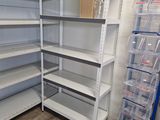 de nombreuses étagères dans un magasin, sur lesquelles sont posés des bacs en plastique