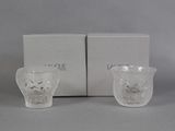 pair of white glass cups with floral designs on them in front of a box