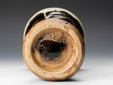a close up of a vase with a brown and black design