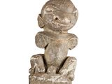 a stone statue of a monkey sitting on a rock