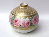 a white and gold vase with pink roses painted on it