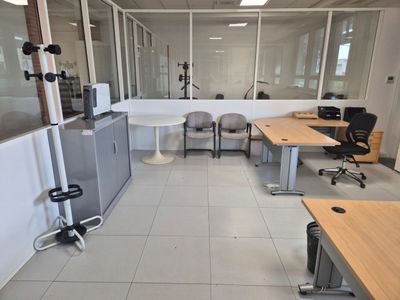 an image of an office with a lot of desks and chairs