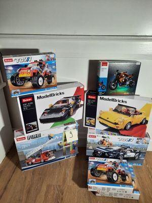 quatre boîtes de Lego posées les unes à côté des autres sur le sol