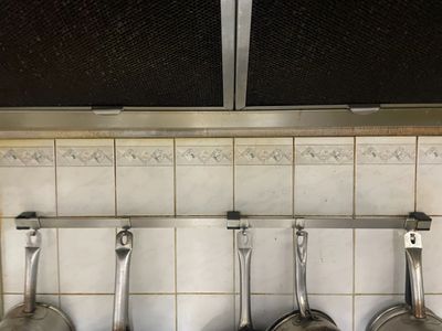 des casseroles et des poêles accrochées au mur de la cuisine