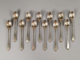 six cuillères en argent sont alignées sur une table