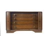 a small wooden chest of drawers next to a remote control