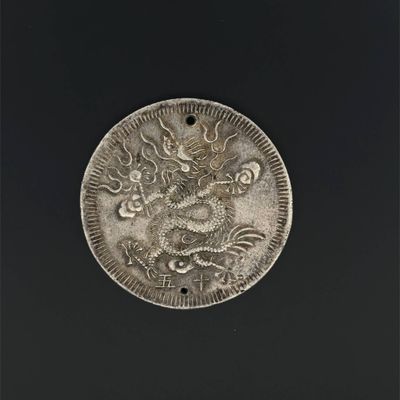 a close up of a silver coin with a dragon on it