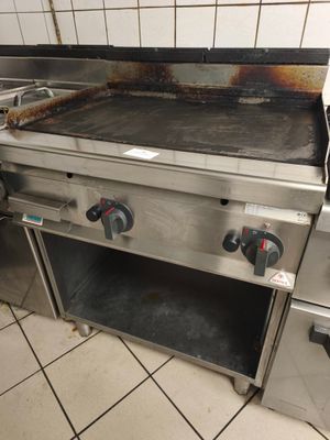 une cuisinière avec une grille au milieu de la cuisine