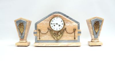 une horloge et deux vases posés sur une surface blanche