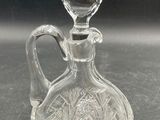 a clear glass bottle with a glass stopper on it